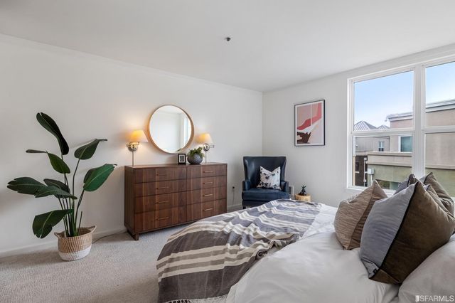 a bedroom with a bed and a potted plant