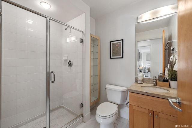 a bathroom with a shower sink vanity mirror and toilet