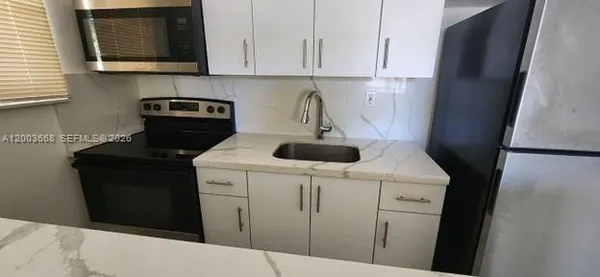 a kitchen with a sink a stove and cabinets