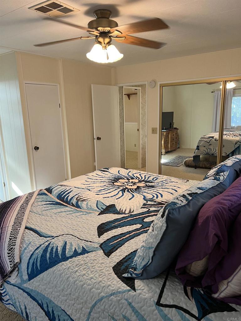 18218 Paradise Mountain Road, Unit SPACE 83 Valley Center, CA 92082 - Photo 11 of 50 a bedroom with a bed and ceiling fan