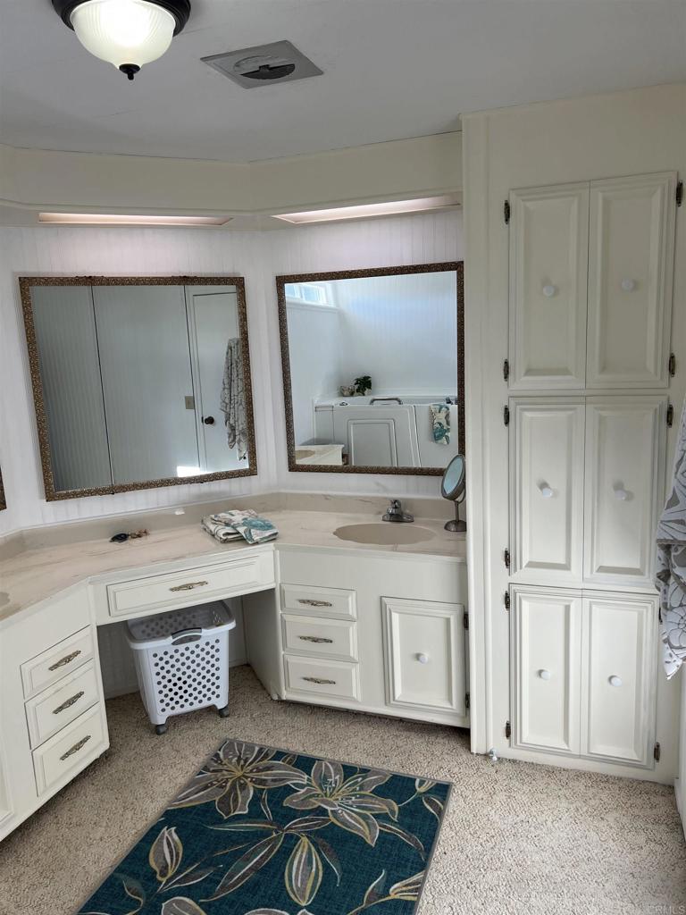 18218 Paradise Mountain Road, Unit SPACE 83 Valley Center, CA 92082 - Photo 16 of 50 a bathroom with a double vanity sink mirror and bathtub