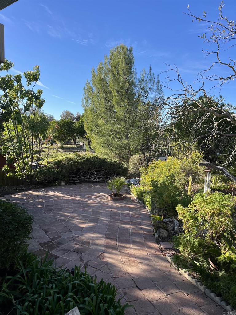 18218 Paradise Mountain Road, Unit SPACE 83 Valley Center, CA 92082 - Photo 2 of 50 a view of a yard with plants and a building