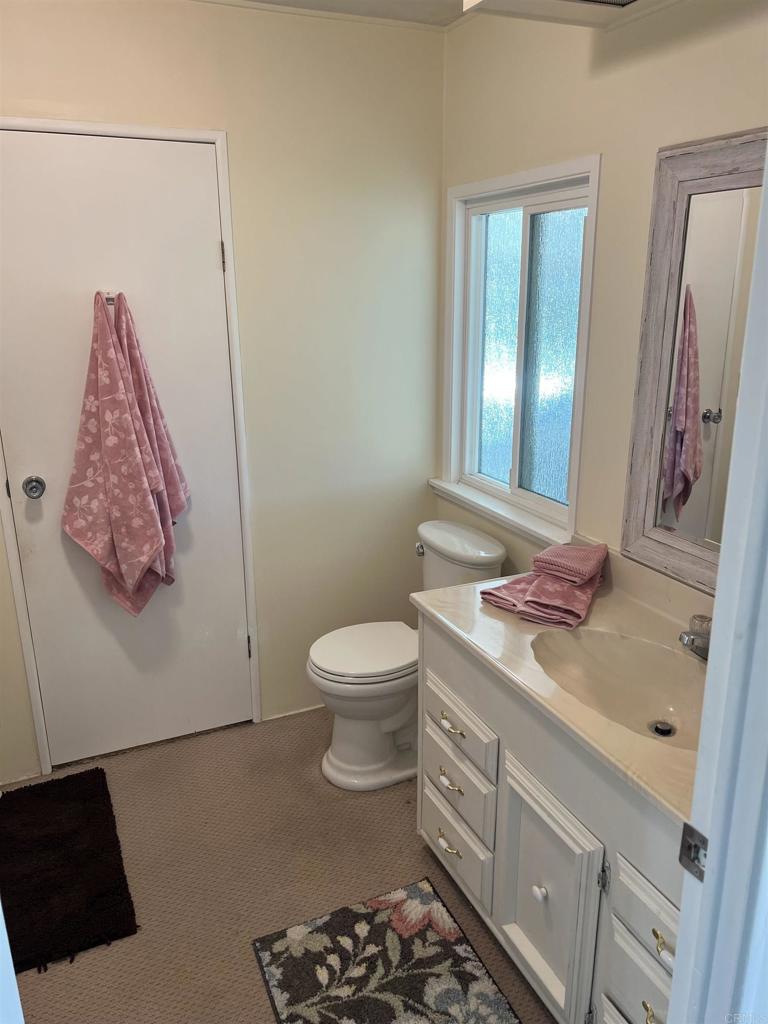 18218 Paradise Mountain Road, Unit SPACE 83 Valley Center, CA 92082 - Photo 4 of 50 a bathroom with a toilet sink and mirror