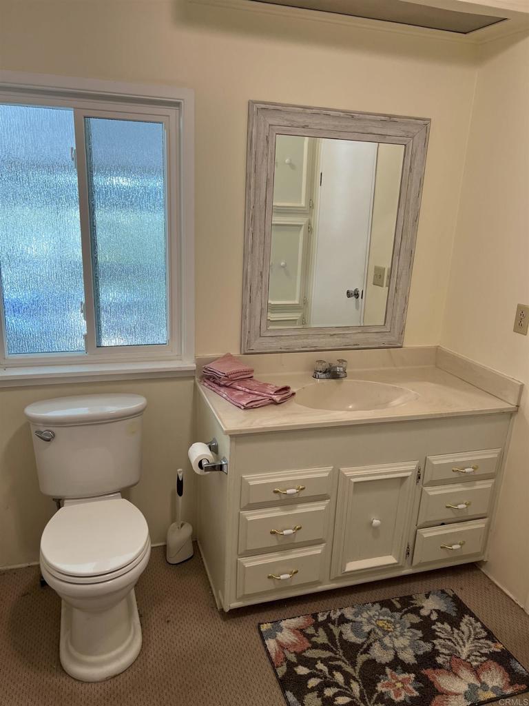 18218 Paradise Mountain Road, Unit SPACE 83 Valley Center, CA 92082 - Photo 7 of 50 a bathroom with a toilet a sink and a mirror
