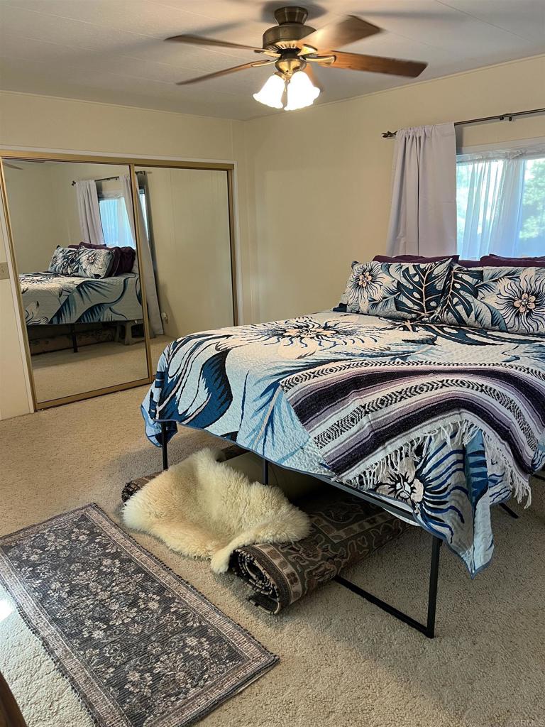 18218 Paradise Mountain Road, Unit SPACE 83 Valley Center, CA 92082 - Photo 10 of 50 a bedroom with a bed and wooden floor