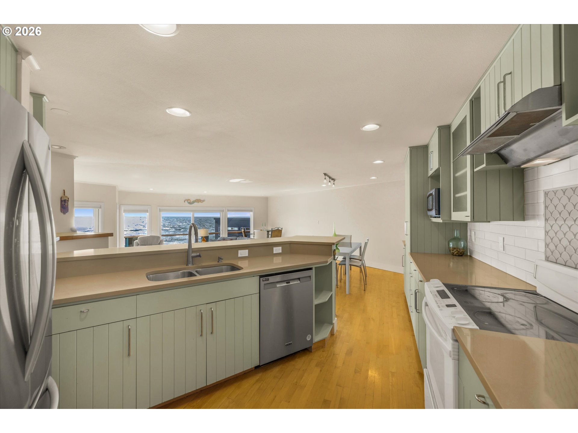 438 Shellmidden Way Yachats, OR 97498 - Photo 16 of 40 a kitchen with a sink stainless steel appliances and cabinets