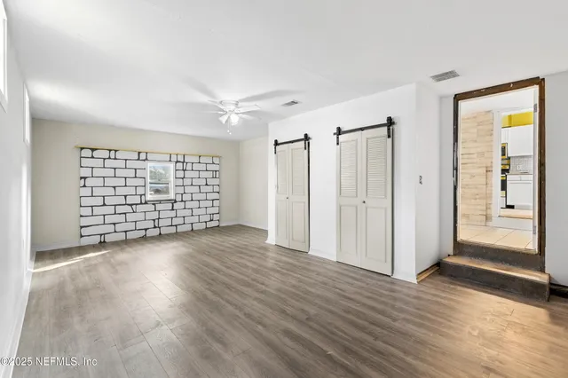 a view of a backyard with plants and large tree
