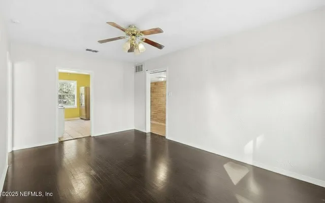 a view of empty room with wooden floor