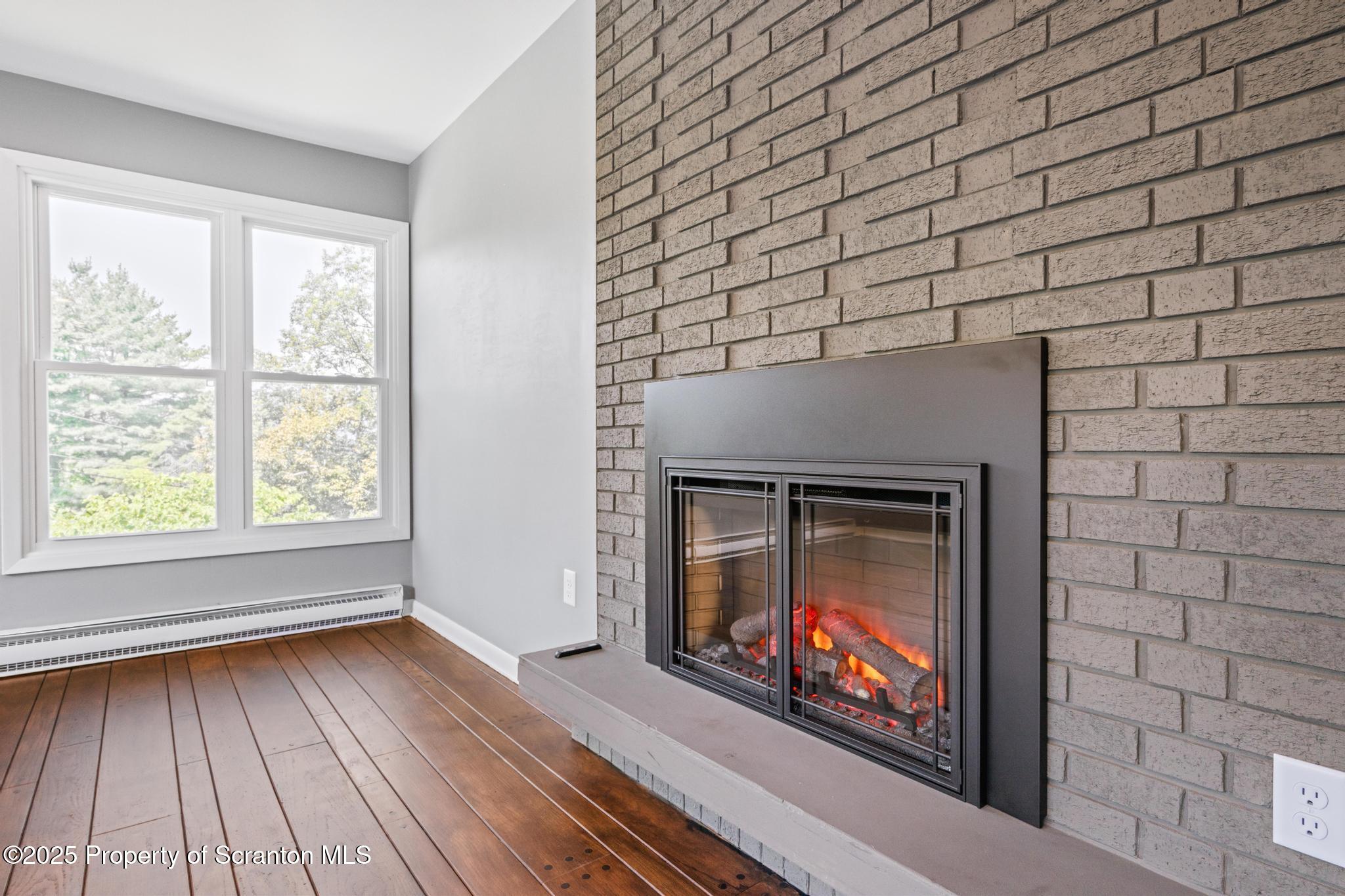 2001 Cleveland Avenue Scranton, PA 18505 - Photo 13 of 87 a living room with a fireplace wooden floor and a bookshelf