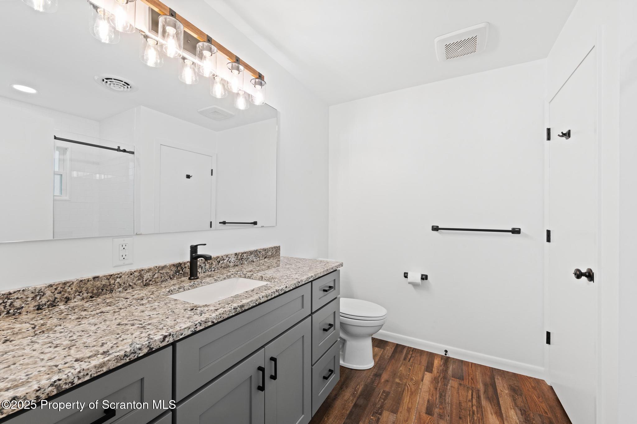 2001 Cleveland Avenue Scranton, PA 18505 - Photo 42 of 87 a bathroom with a granite countertop sink toilet and a mirror