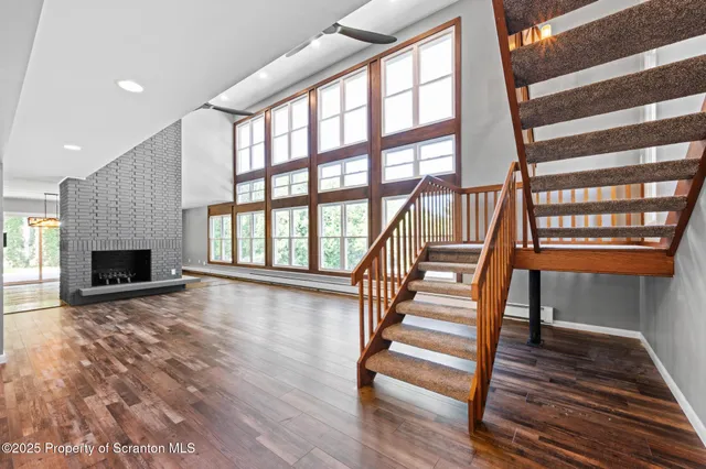 a view of an empty room with wooden floor fire place and a fireplace