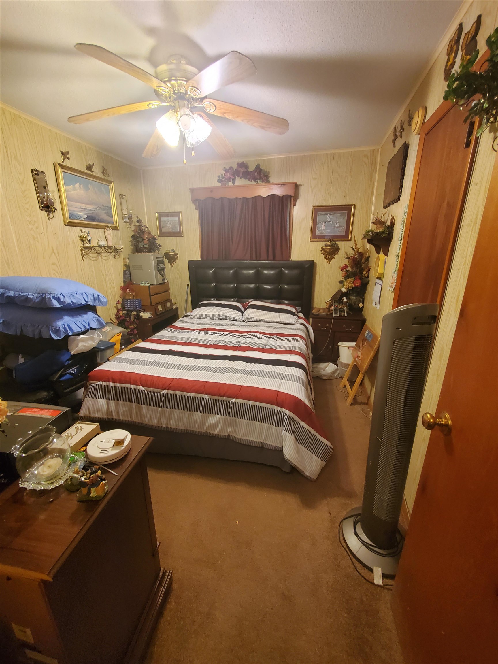 147 Rogers Street Sharon, TN 38255 - Photo 10 of 16 Bedroom featuring a ceiling fan with integrated lighting, wood-finish wall paneling, and brown carpet flooring