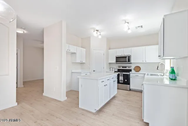 a kitchen with stainless steel appliances and white cabinets