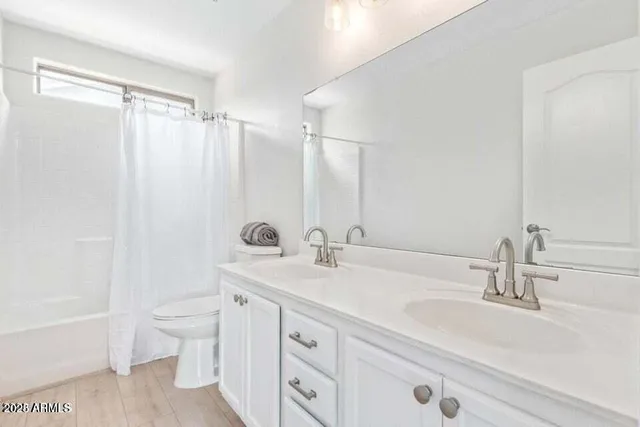 a bathroom with a double vanity sink toilet and shower