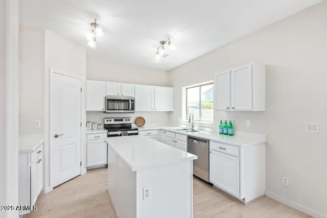 a kitchen with cabinets a sink and steel appliances