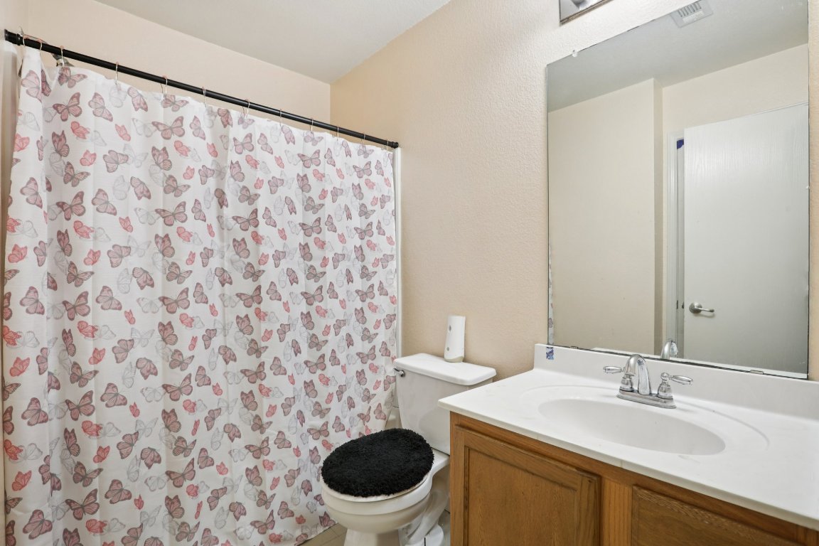 6605 Quinton Drive Austin, TX 78747 - Photo 14 of 19 a bathroom with a granite countertop sink a toilet and a mirror