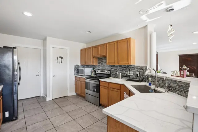 a kitchen with granite countertop a sink stainless steel appliances and cabinets