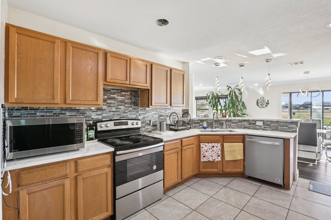 6605 Quinton Drive Austin, TX 78747 - Photo 8 of 19 a kitchen with granite countertop a sink stainless steel appliances and cabinets