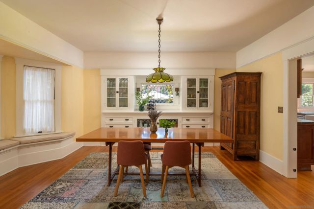 a dining room with furniture a chandelier and wooden floor
