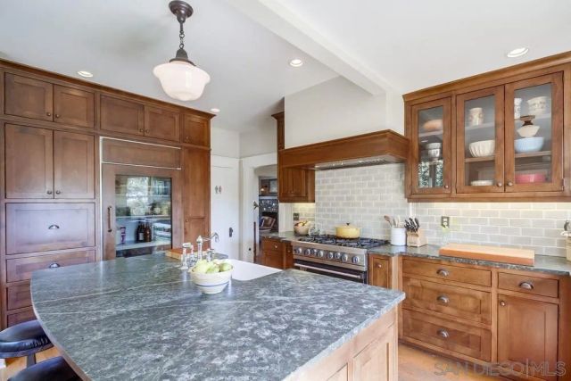 a kitchen with stainless steel appliances granite countertop a stove and more cabinets