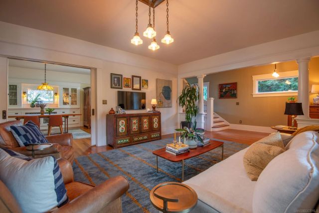 a living room with furniture a chandelier and a dining table