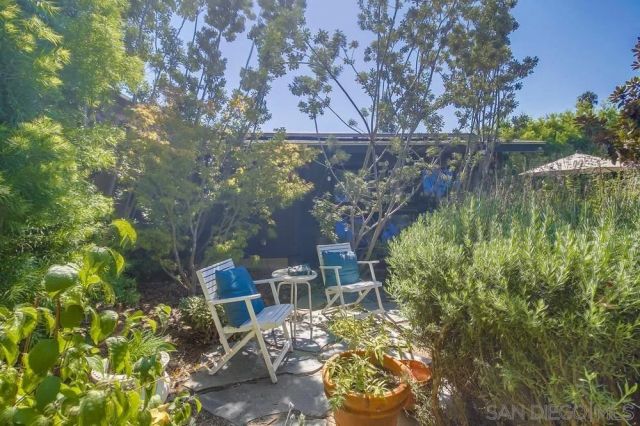 a view of a patio with a table and chairs under an umbrella