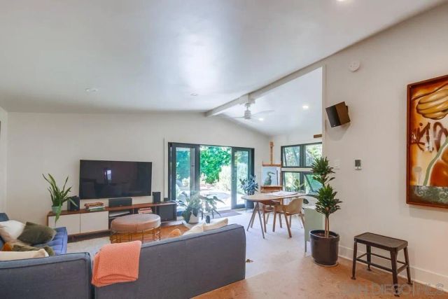a backyard of a house with table and chairs under an umbrella