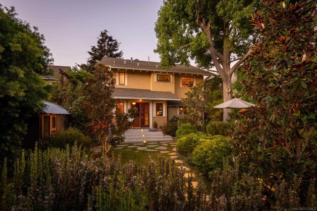 a front view of a house with yard and trees