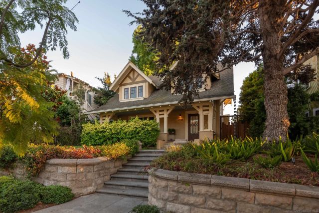 a front view of a house with a yard and potted plants
