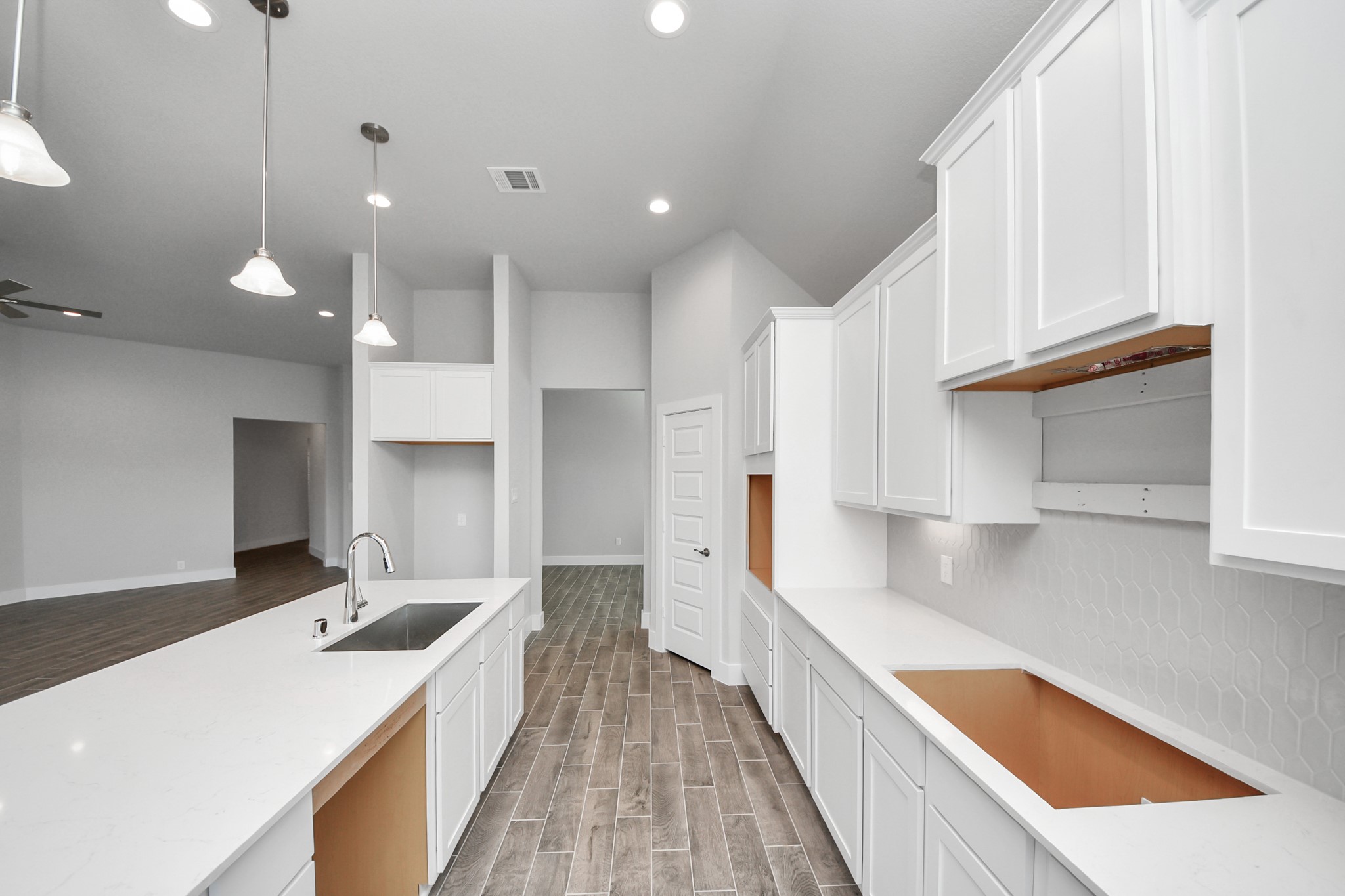 3121 Skerne Spring Dr Spring Spring, TX 77373 - Photo 23 of 44 This kitchen is truly a chef's dream! This haven Boasts high ceilings, recessed & pendant lighting, stained wood cabinets, granite countertops, stainless steel appliances, a modern tile backsplash. All of this overlooks your expansive family room, creating a perfect space for culinary delights and family gatherings.