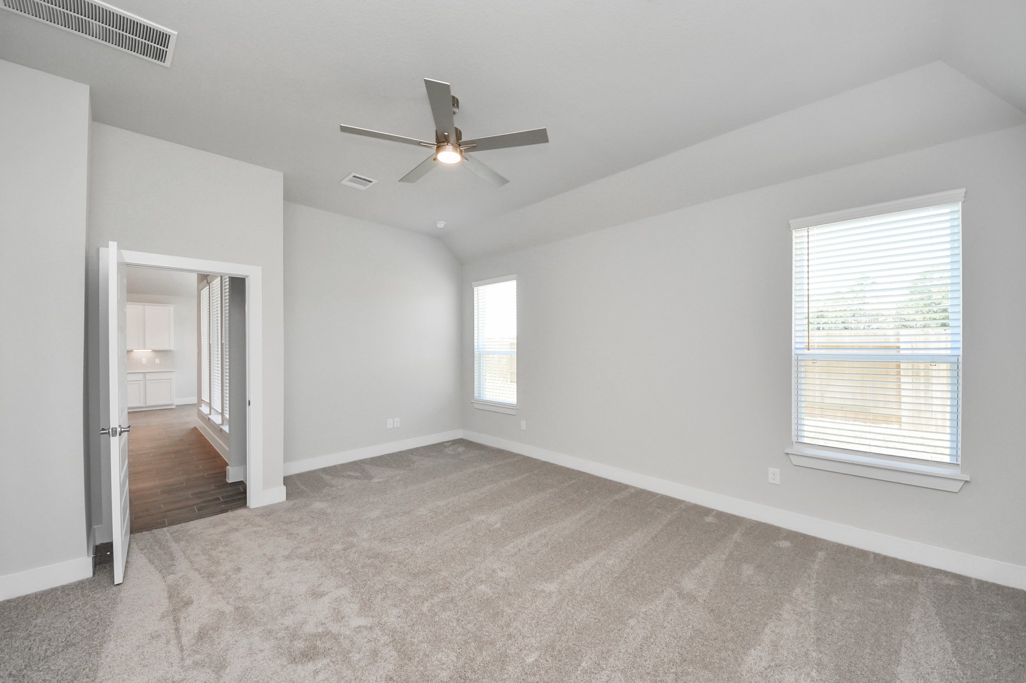 3121 Skerne Spring Dr Spring Spring, TX 77373 - Photo 31 of 44 Escape and relax in the exquisite primary suite, a haven to unwind after a long day. The spacious room, boasts plush carpeting, soothing paint tones, high ceilings, and expansive windows adorned with privacy blinds.