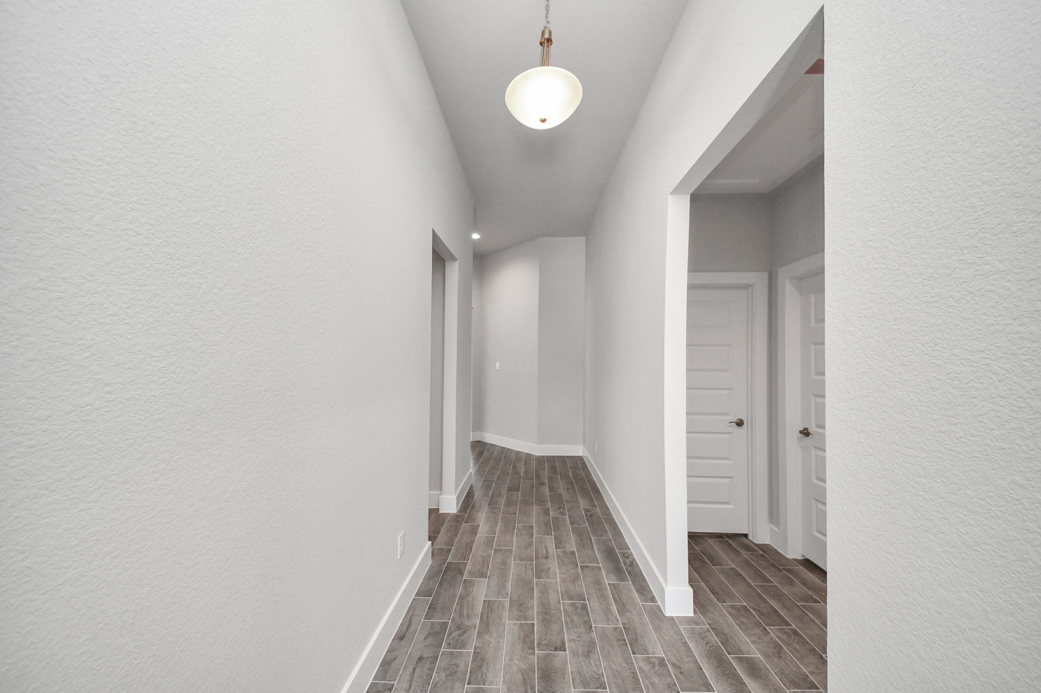 3121 Skerne Spring Dr Spring Spring, TX 77373 - Photo 6 of 44 As you step into the threshold of this luxurious home, you'll soon be welcomed by an elegant glass door (to be installed). Inside, soaring ceilings amplify the spaciousness, while the refined wood-look tile flooring and oversized baseboards exude sophistication and charm.