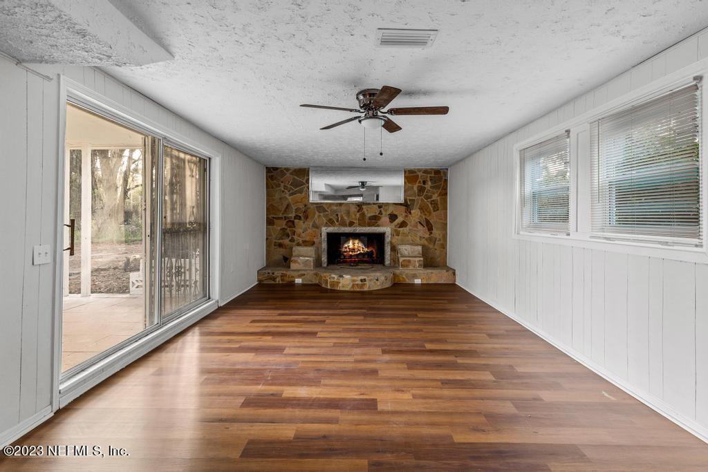 3616 Freeman Road Jacksonville, FL 32207 - Photo 21 of 41 a view of an empty room with wooden floor fireplace and a window
