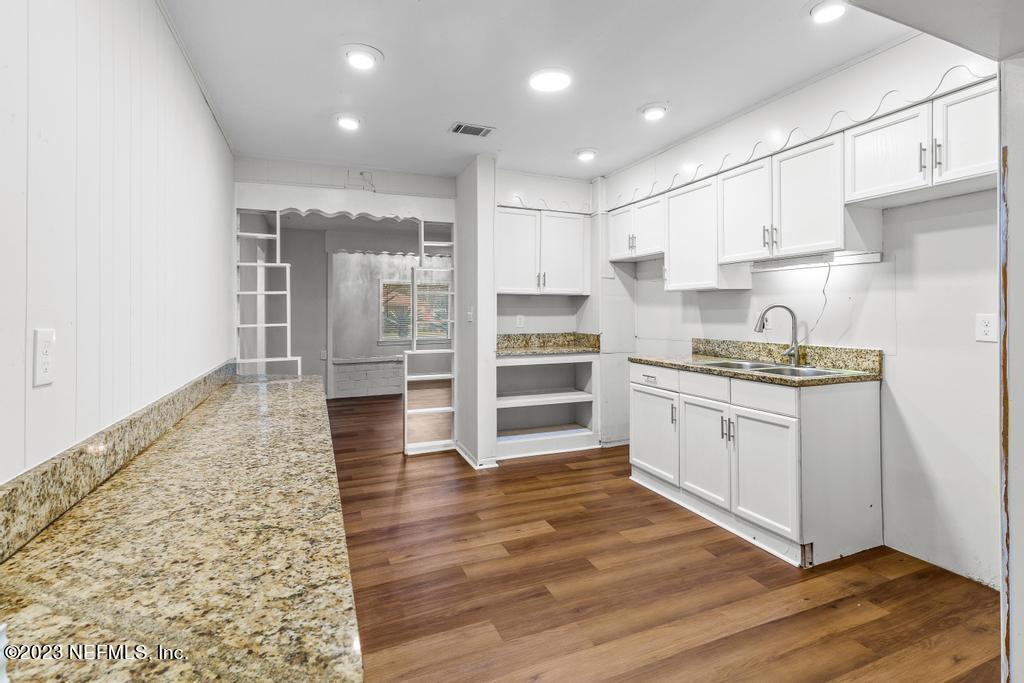 3616 Freeman Road Jacksonville, FL 32207 - Photo 24 of 41 a kitchen with wooden floors and cabinets