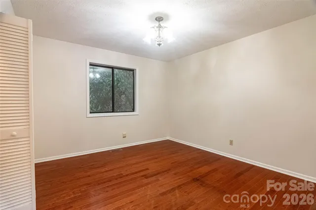 a view of a room with wooden floor and windows