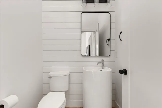 a bathroom with a toilet sink and mirror