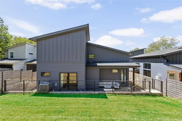 a view of a house with a yard and a large tree