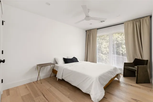 a bedroom with a bed and a flat tv screen on a dresser