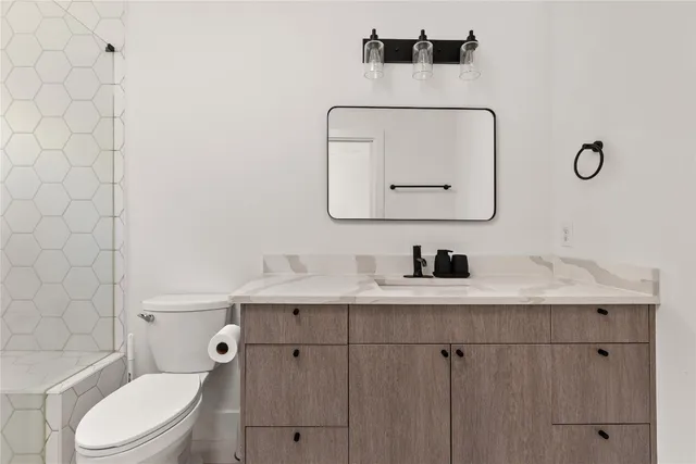a bathroom with a toilet a sink and mirror