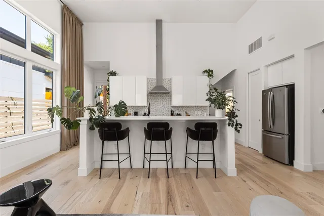 a kitchen with stainless steel appliances kitchen island granite countertop a table and chairs in it