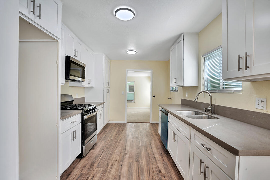 3050 Lime Street Riverside, CA 92501 - Photo 8 of 35 a kitchen with granite countertop a sink wooden floor and stainless steel appliances