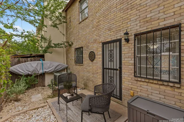 a view of a chair and table in backyard of the house