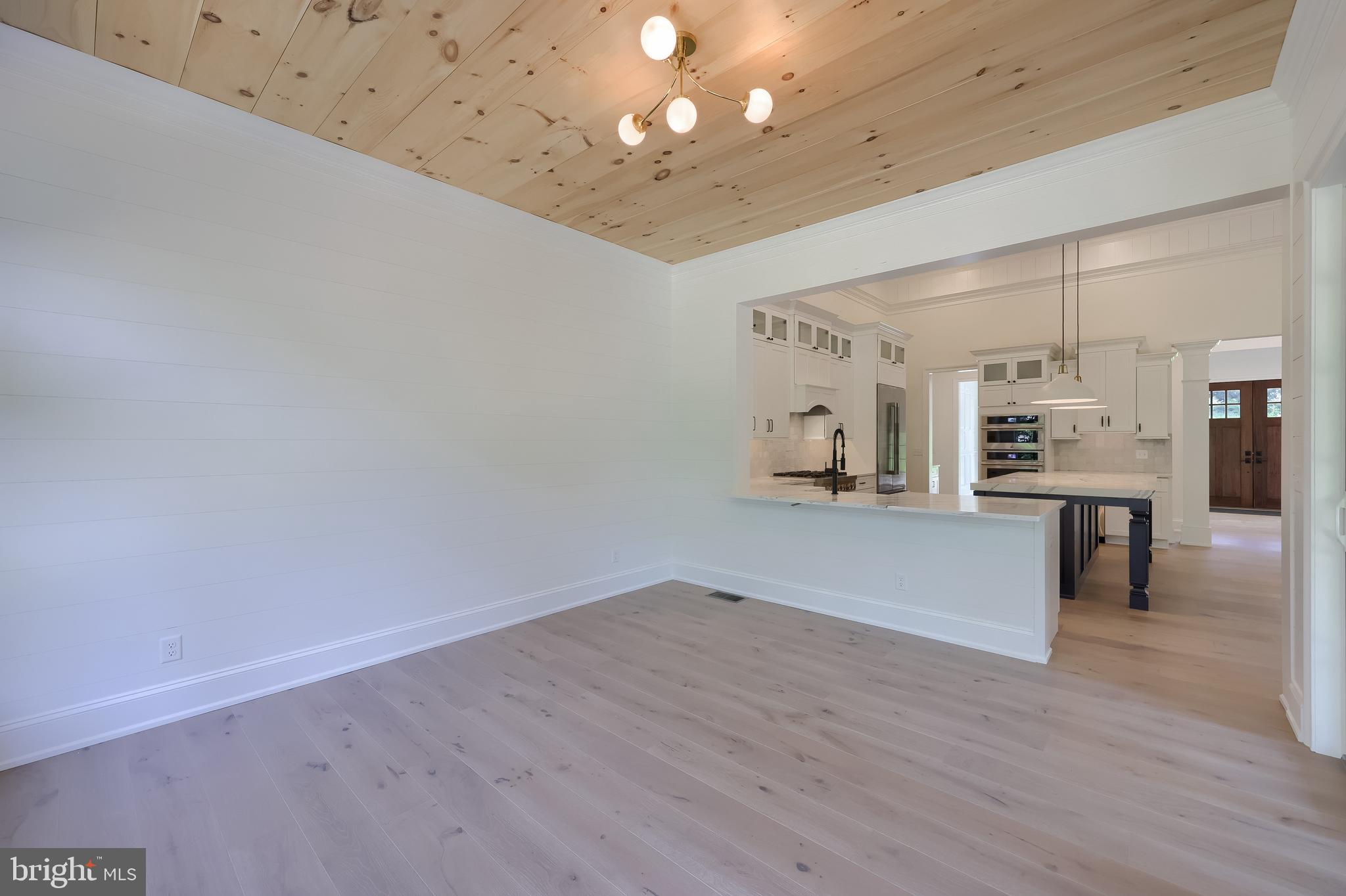 421 Southampton Drive Lititz, PA 17543 - Photo 16 of 49 an empty room with wooden floor and a kitchen