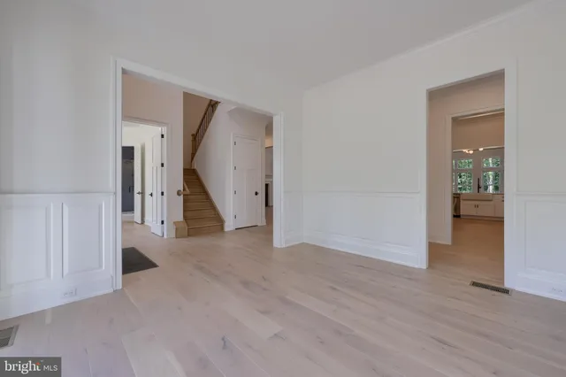 a view of a hallway with wooden floor and a living room