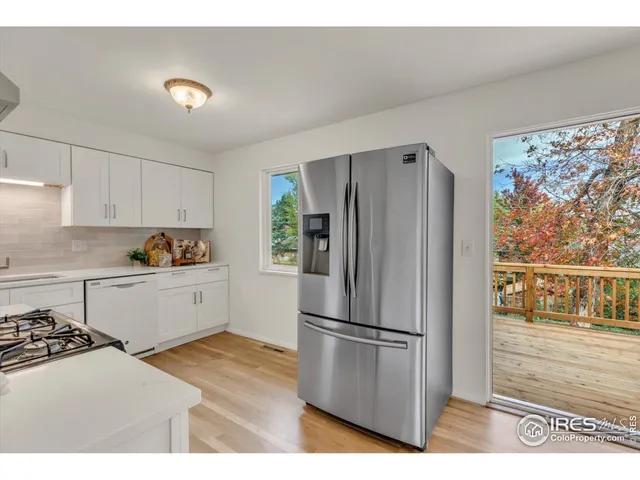 a kitchen with granite countertop a refrigerator and a stove top oven