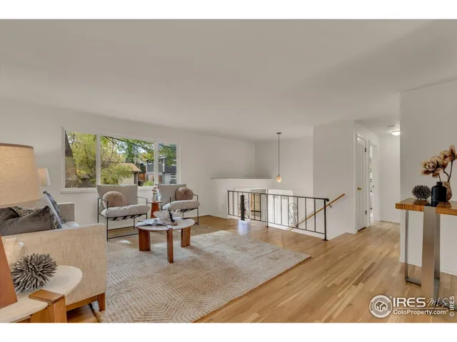 a living room with furniture wooden floor and a large window