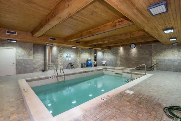 a view of a swimming pool with a patio and a garden