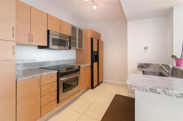 a kitchen with stainless steel appliances granite countertop a sink stove and microwave