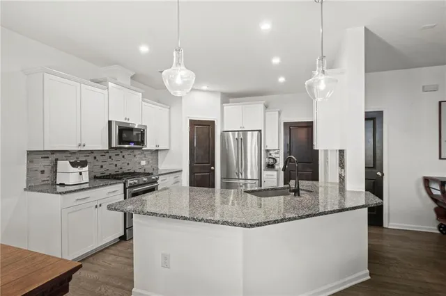 a kitchen with stainless steel appliances granite countertop a sink stove and microwave