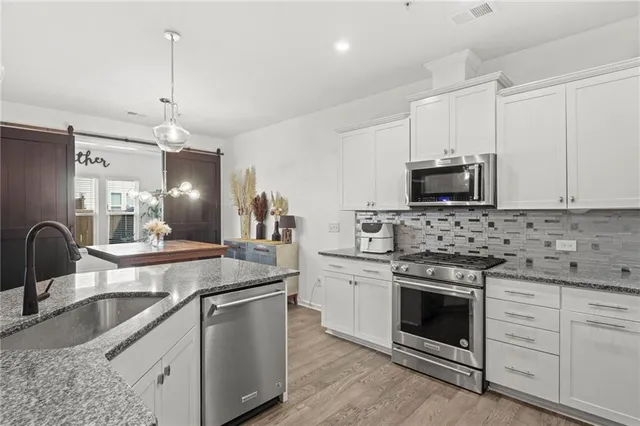 a kitchen with stainless steel appliances granite countertop a stove a sink and a refrigerator